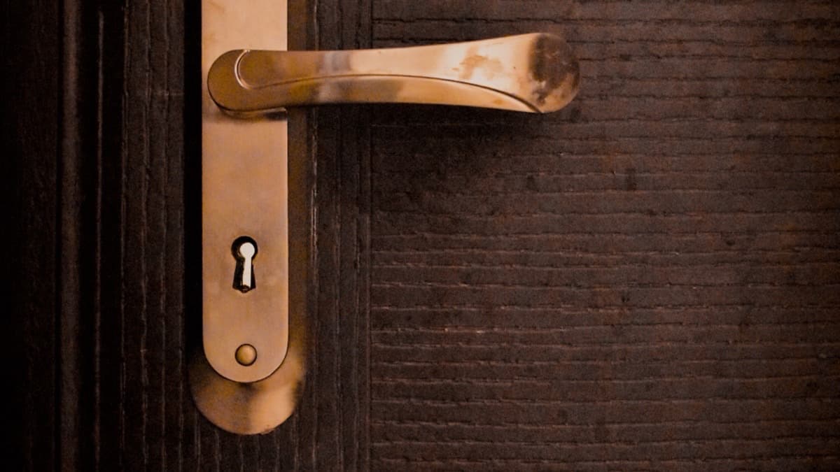 Poignée dorée et serrure d'une porte d'entrée en bois