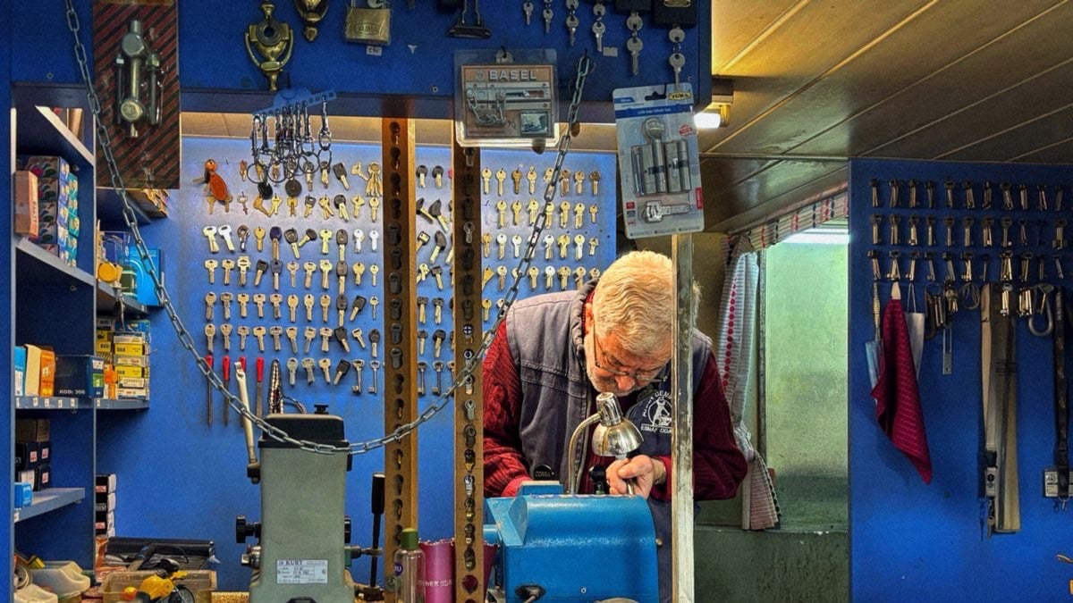 Serrurier professionnel expérimenté taillant une clé dans son atelier équipé