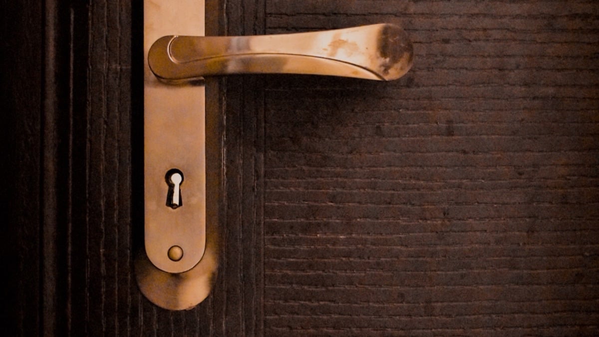 Poignée dorée et serrure d'une porte d'entrée en bois