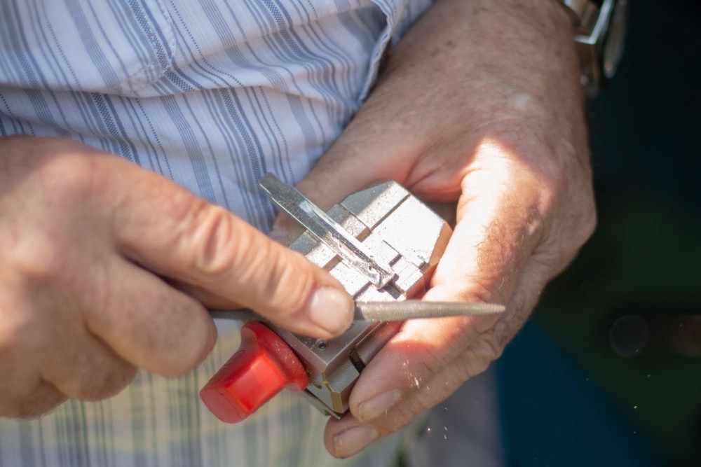 Serrurier taillant une clé sur un gabarit de duplication